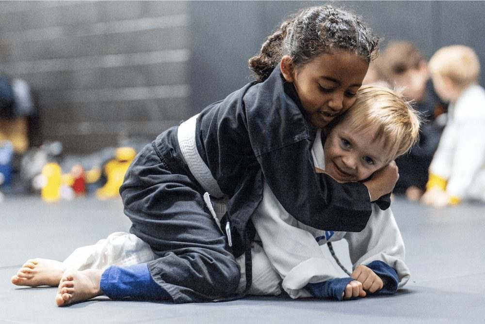 Two young WDC BJJ students grappling on the mats during a kids jiu-jitsu class in Takoma Park